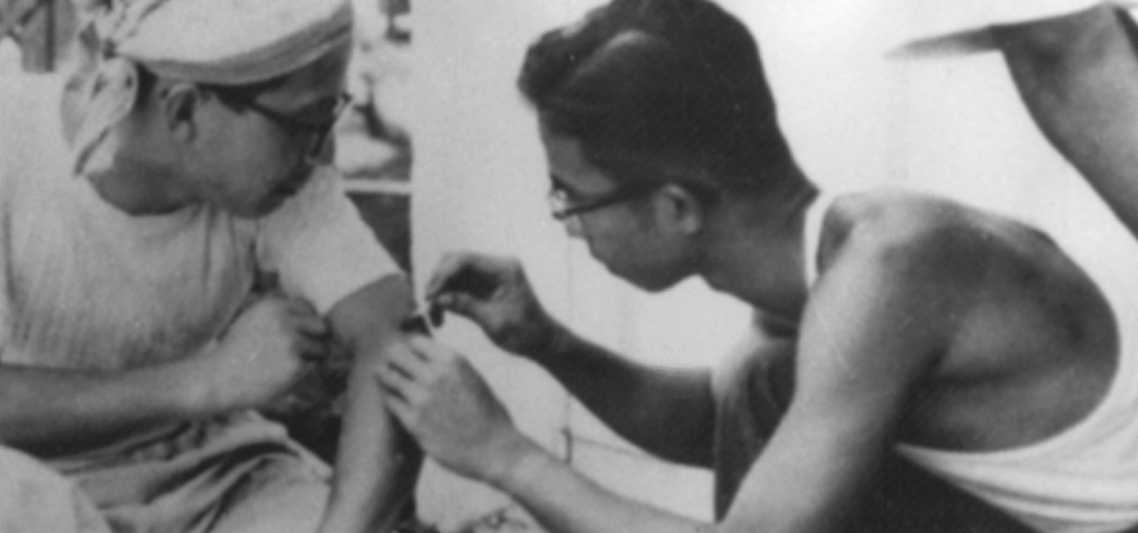 Two individuals working together in a medical or educational setting, focusing on a task