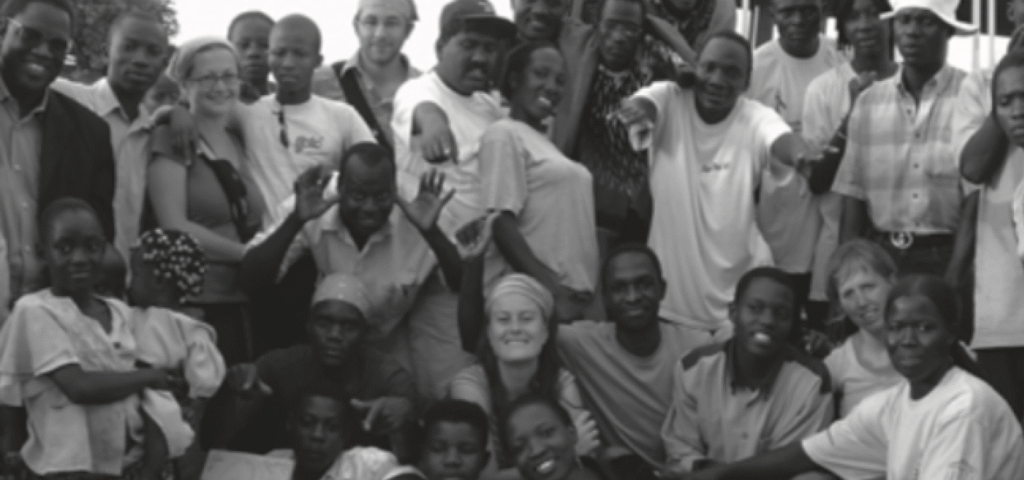 Group of diverse individuals posing together in a black-and-white photograph, showcasing unity and camaraderie